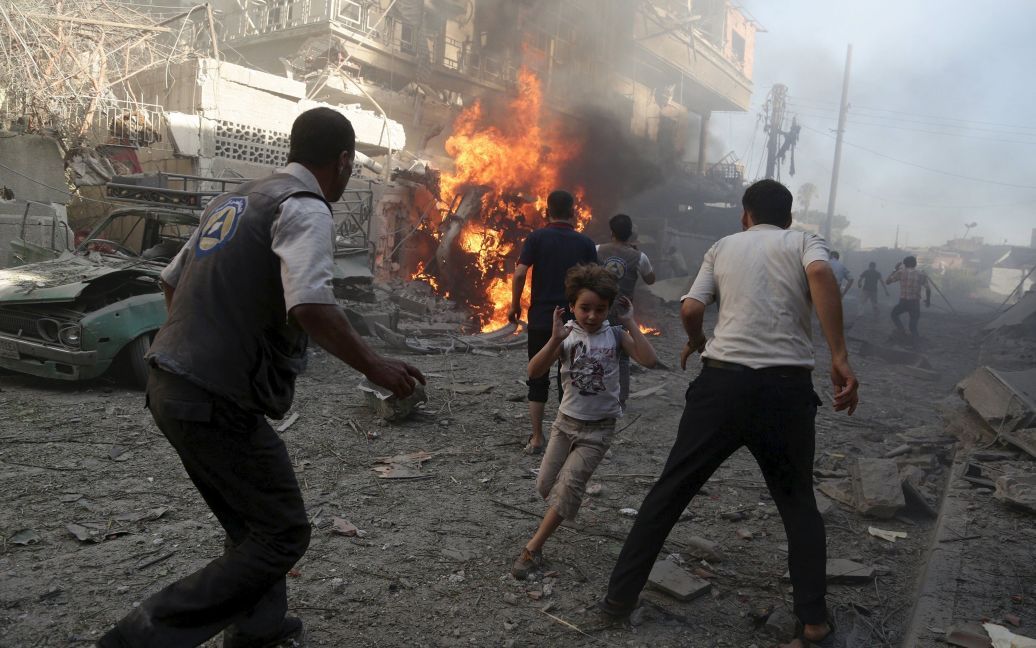 Люди в панике бегут во время авиаударов по городу Дума в Сирии со стороны сил Башара Асада. В Сирии продолжается кровопролитная гражданская война, унесшая жизни более 200 тысяч людей. / © Reuters