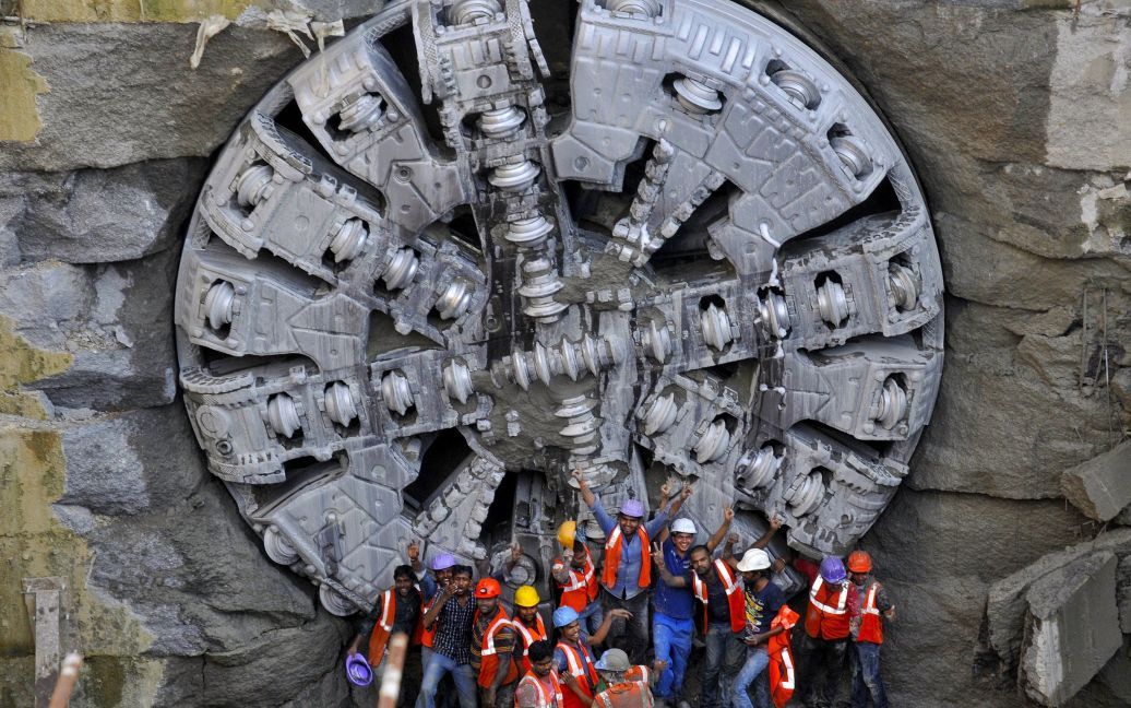 Строители метро стоят возле подземного "комбайна", который успешно прорыл туннель для метро в индийском городе Бангалор / © Reuters