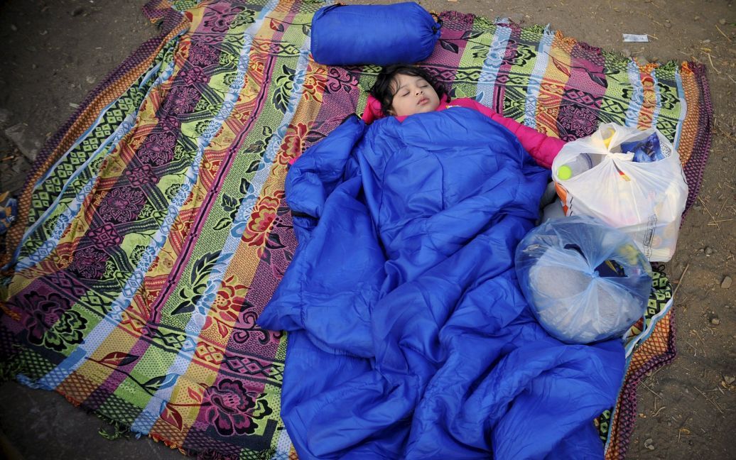 Девочка-мигрант спит на границе между Македонией и Грецией. Тысячи беженцев ждут, когда они смогут войти в македонский город Гевгелия, чтобы продолжить свой путь в Западную Европу. / © Reuters