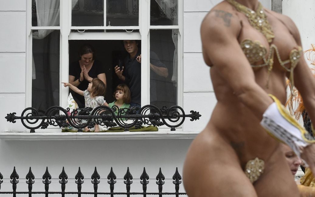 Семья из своего дома наблюдает за самым большим в Европе карнавалом, что происходит в западном районе Лондона Ноттинг-Хилл / © Reuters