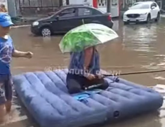 После ливня житель Днепра посреди улицы устроил рыбалку на матрасе: видео