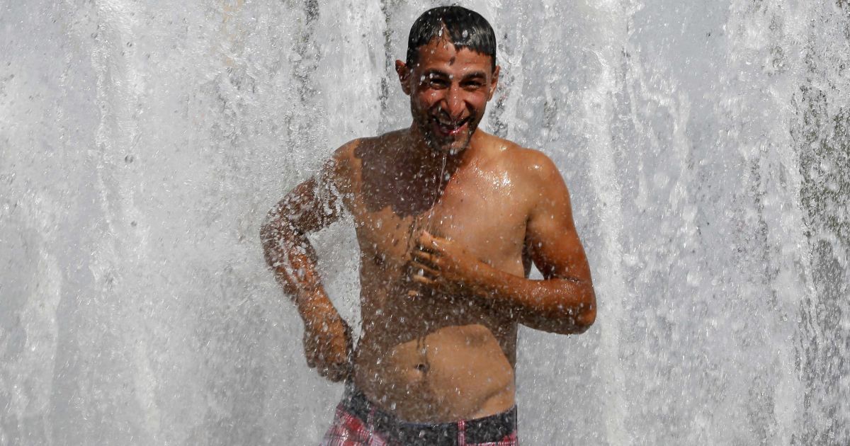 Немцы от жары спасаются зонтиками и прохладной водой. / © Reuters