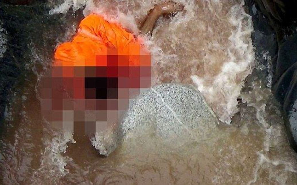 Кадры из видео боевиков показывают тело полицейского на дне водопада. / © Daily Mail