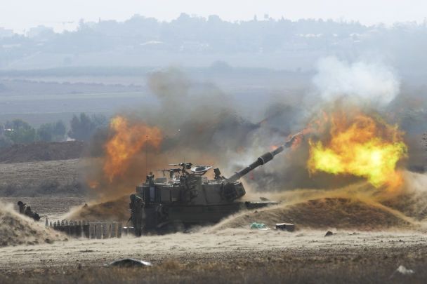 Flames erupt as Israeli The 1st mobile artillery unit fires a shell from southern Israel into side of the Gaza Strip, at position 