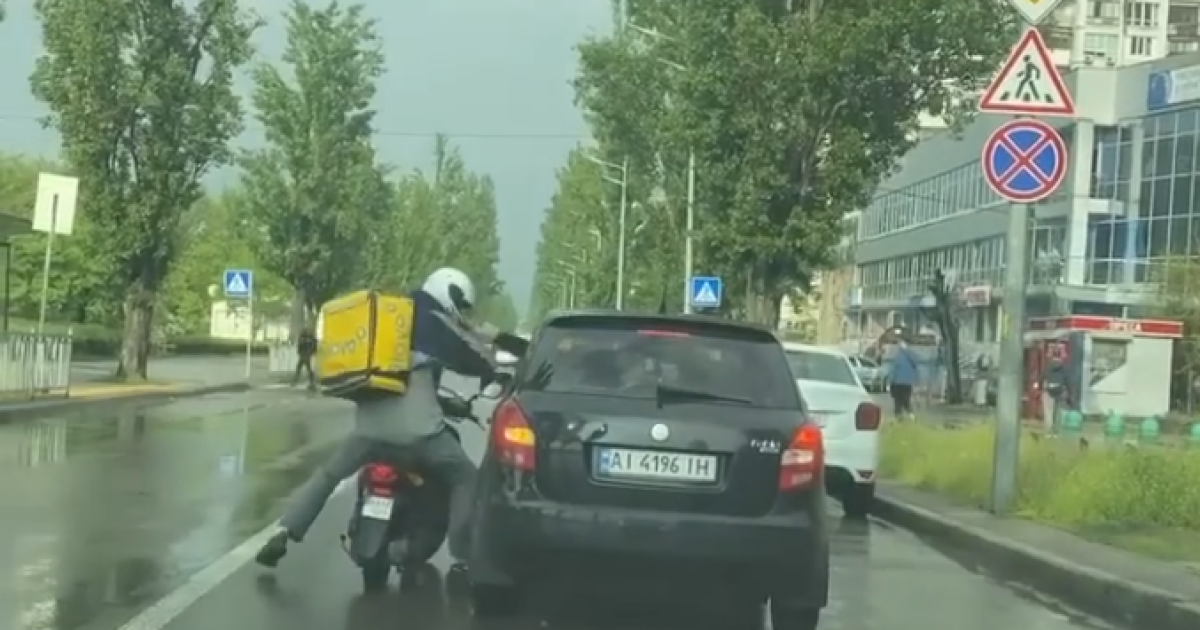 В Киеве прямо на дороге подрались курьер службы доставки на скутере и водитель авто: видео