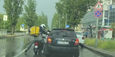 У Києві просто на дорозі побилися кур'єр служби доставки на скутері і водій авто: відео