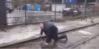 В Киеве неизвестный напал на журналистов, а затем поскользнулся и упал в лужу: видео