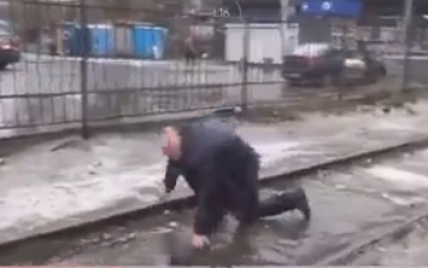 В Киеве неизвестный напал на журналистов, а затем поскользнулся и упал в лужу: видео