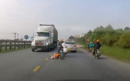 Мать и ребенок на скутере чудом спаслись от колес фуры во Вьетнаме