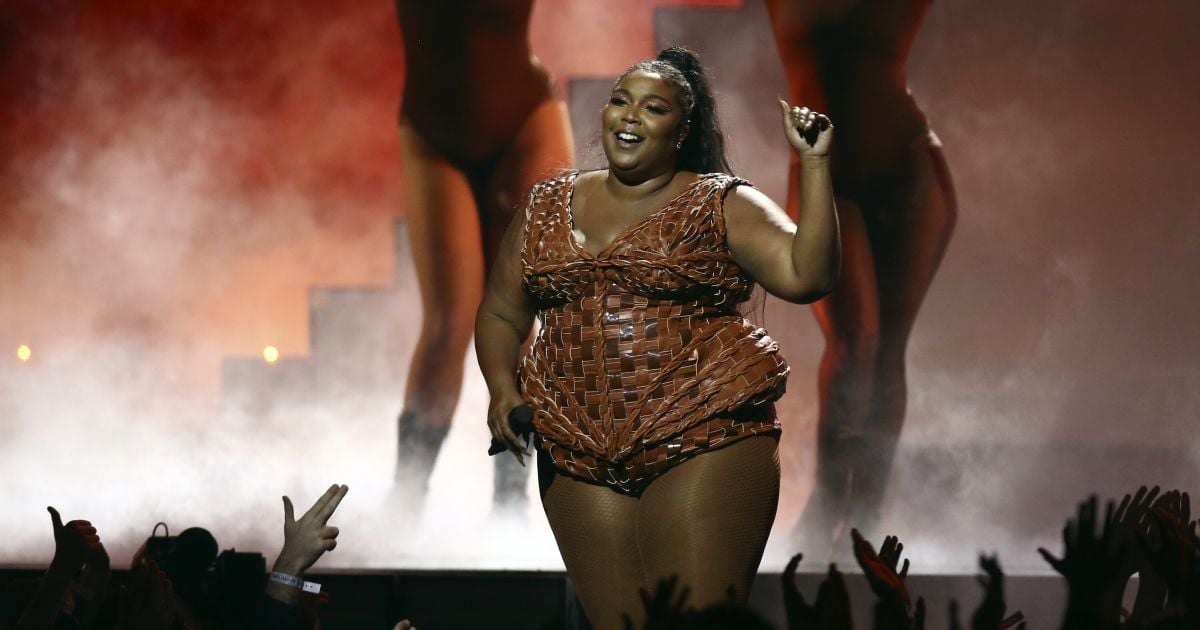 Пышнотелая Lizzo в черной рубашке едва прикрыла голую грудь