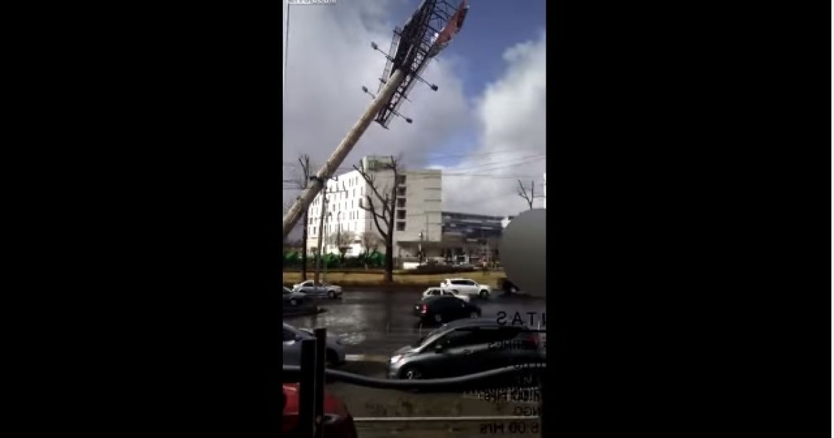 Очевидец снял на видео падение огромного рекламного щита на оживленную дорогу