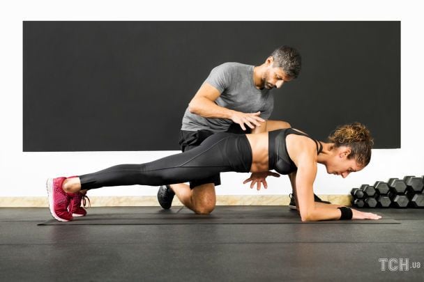 Жінка виконує планку з тренером / © Credits