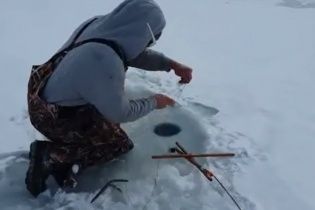 Друг снял на видео, как шокированный рыбак достал из проруби неожиданную добычу