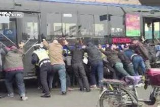 У Китаї заради порятунку чоловіка люди підняли автобус