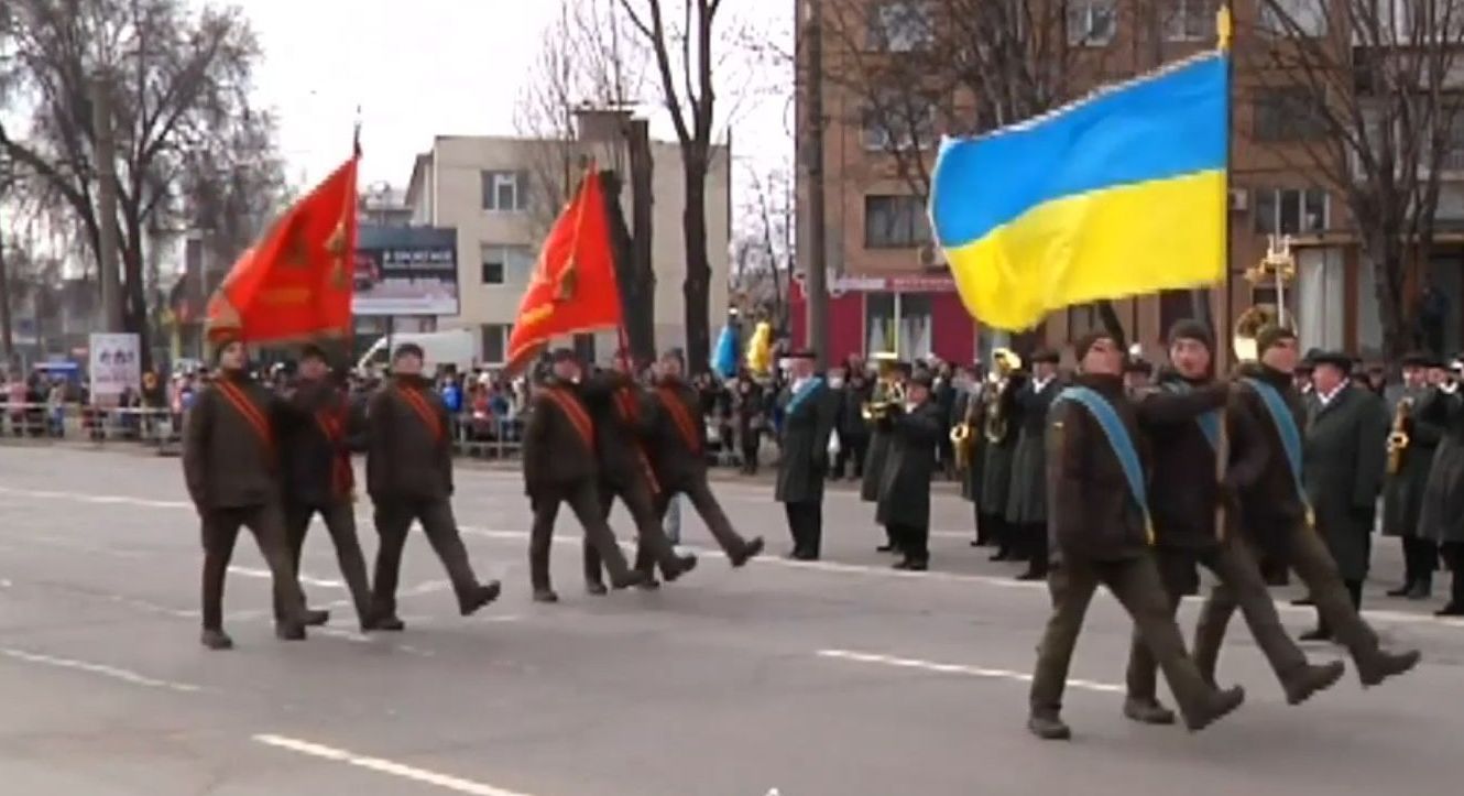 Нацгвардийцы прошлись по улицам Кривого года, держа в руках красные флаги с cерпом и молотом