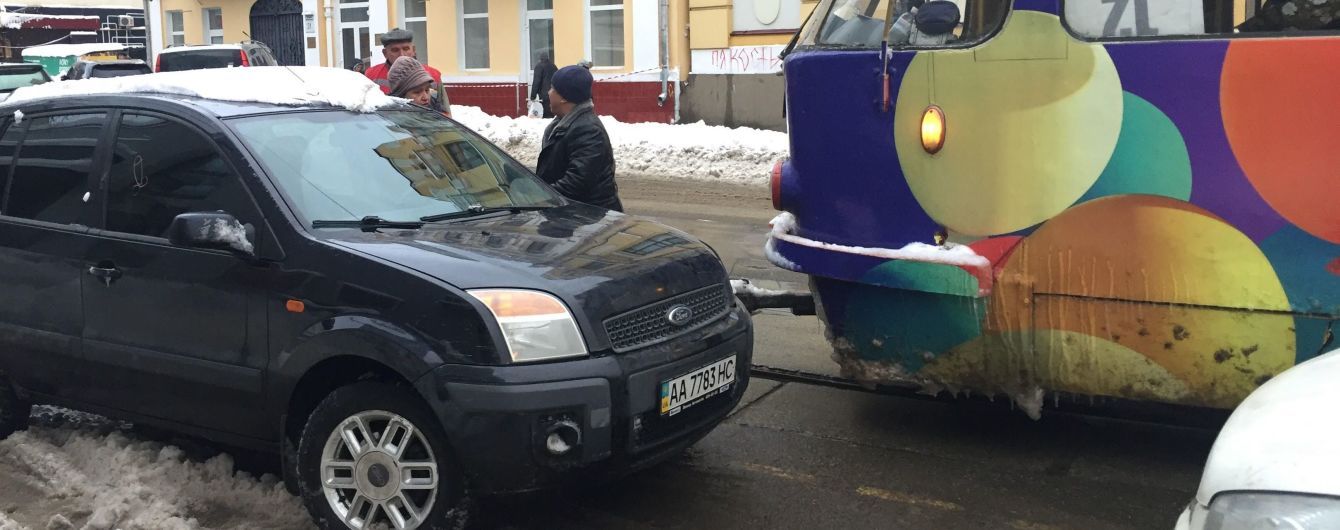 Вузькі вулички Києва стають капканом для трамваїв, бо водії через сніг паркуються ледь не по центру дороги