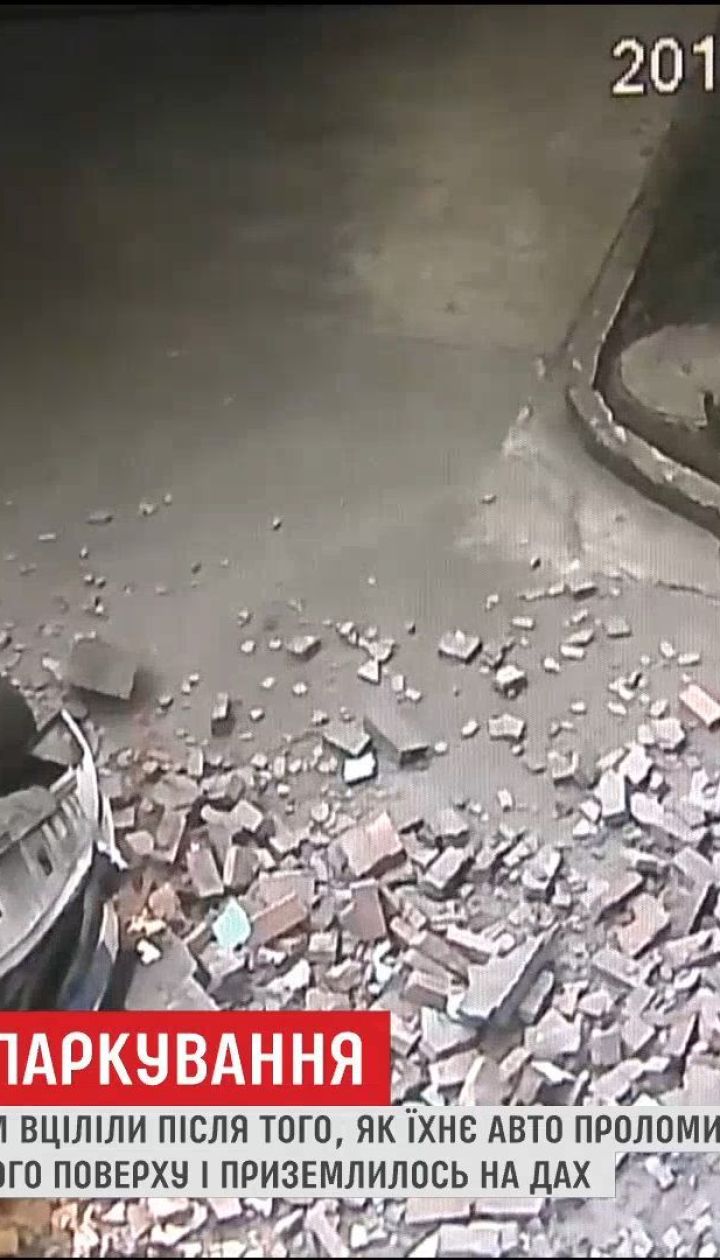 В Китае водитель и его пассажирка уцелели после падения автомобиля со второго этажа паркинга