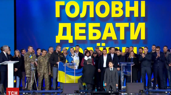 Зеленський та Порошенко стали на коліна перед рідними загиблих у війні під час дебатів на "Олімпійському"