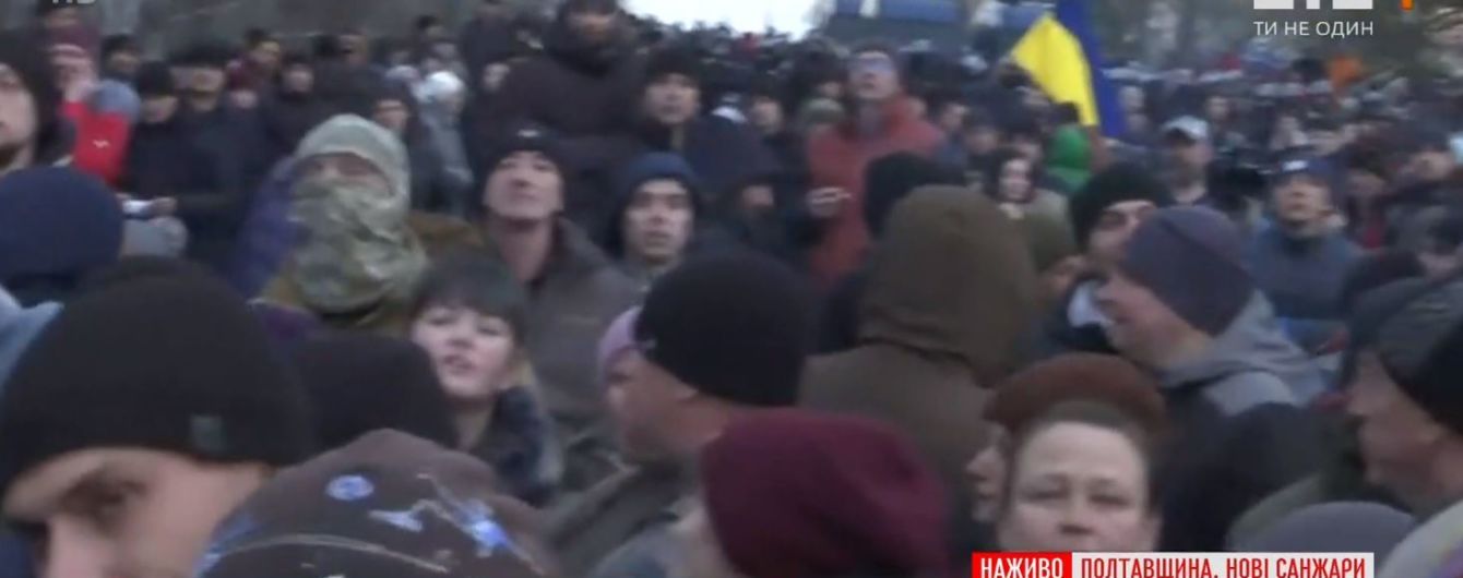 У Нових Санжарах люди стають у "живий щит" перед приїздом автобусів з евакуйованими з Китаю