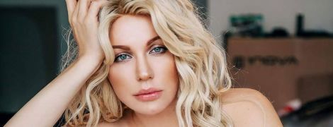 Травесті-діва Монро у плащі та колготках в сіточку звабливо позувала на гардеробній вішалці