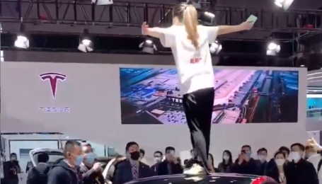 Владелица Tesla на крыше электрокара устроила громкий скандал во время автошоу в Шанхае: видео