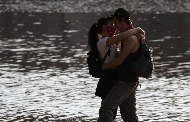 После снятия карантина пара наслаждается теплой погодой у реки Влтава в Праге / © Associated Press