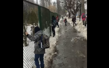 На учебу, держась за забор: в Киеве дорогу в школу преградила огромная лужа