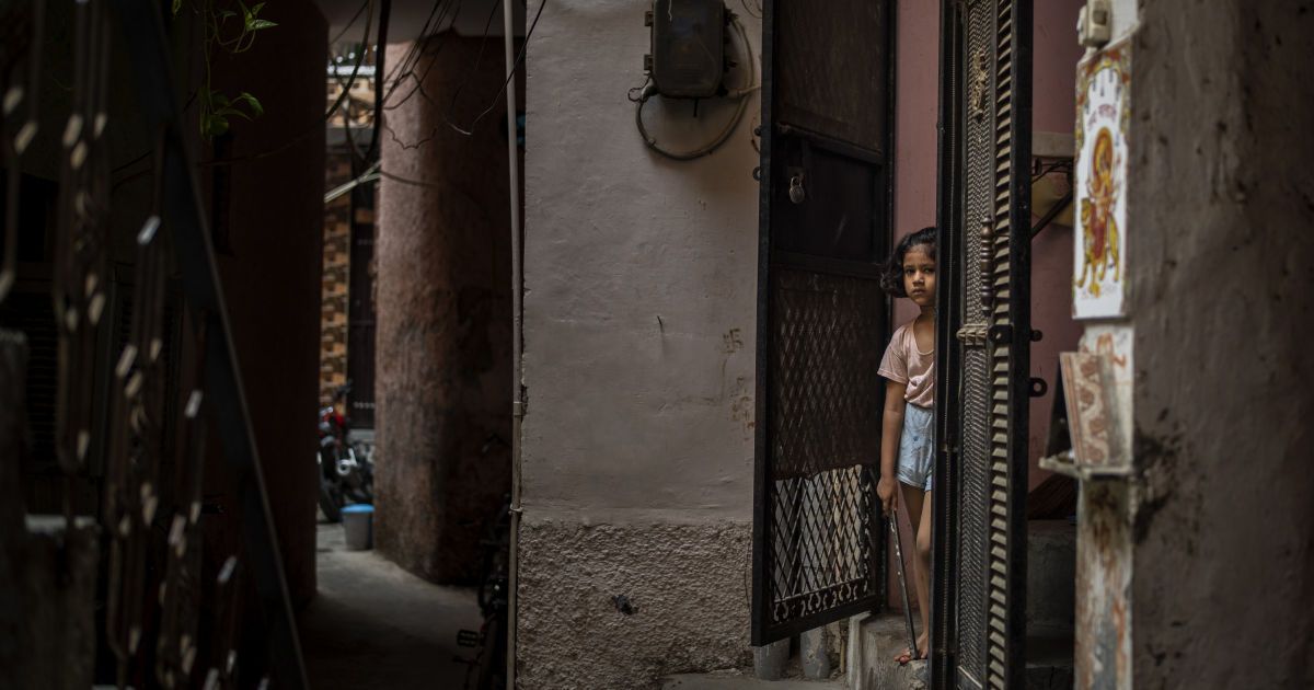 Маленька дівчинка стоїть біля входу в свій будинок неподалік дому вбитої 9-річної дівчинки / © Associated Press