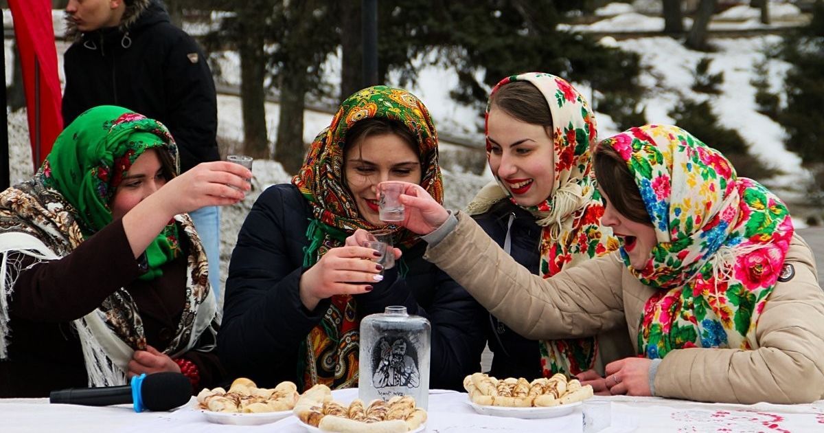 Девушки едят блины во время празднования Масленицы в Чернигове.