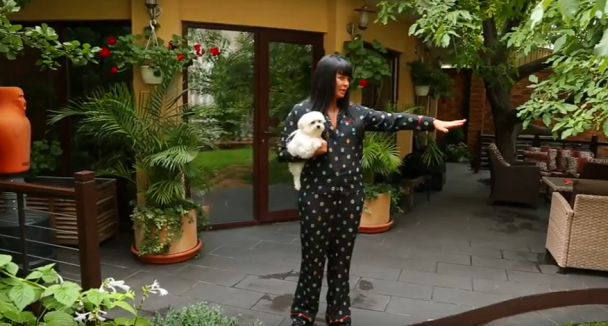 Ассія Ахат на тлі свого будинку