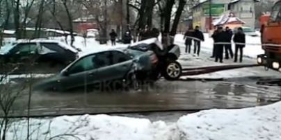 В России коммунальщики феерично "добили" авто, которое застряло в яме посреди дороги