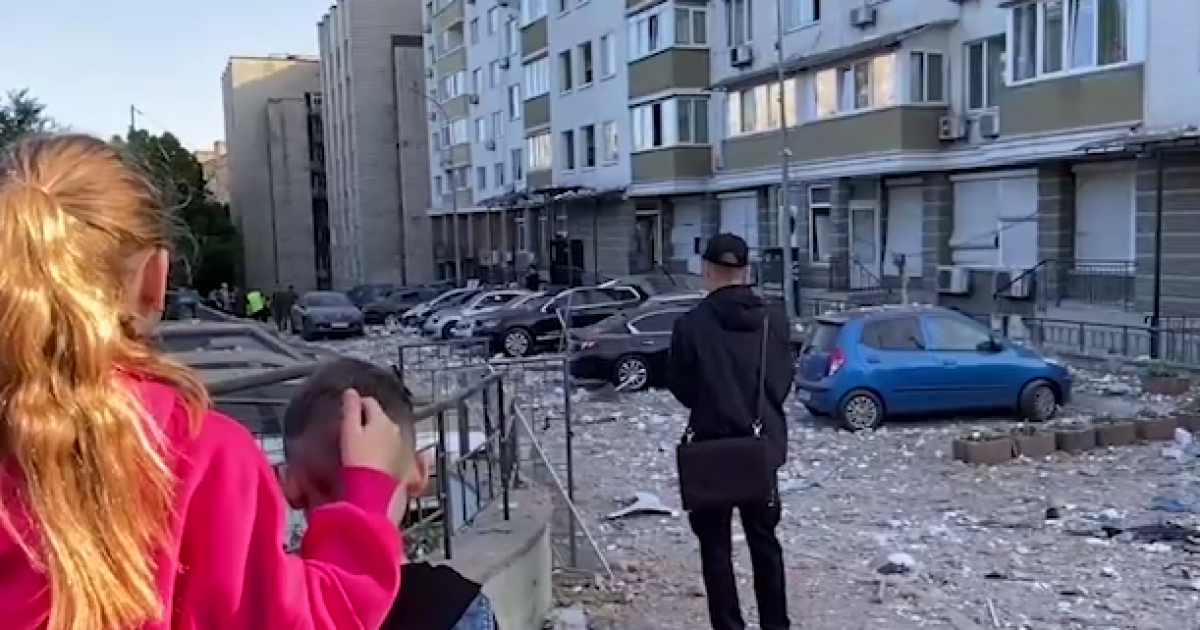 Дети в Голосеевском районе стоят возле многоэтажки, куда попали обломки сбитого дрона ночью 30 мая.
