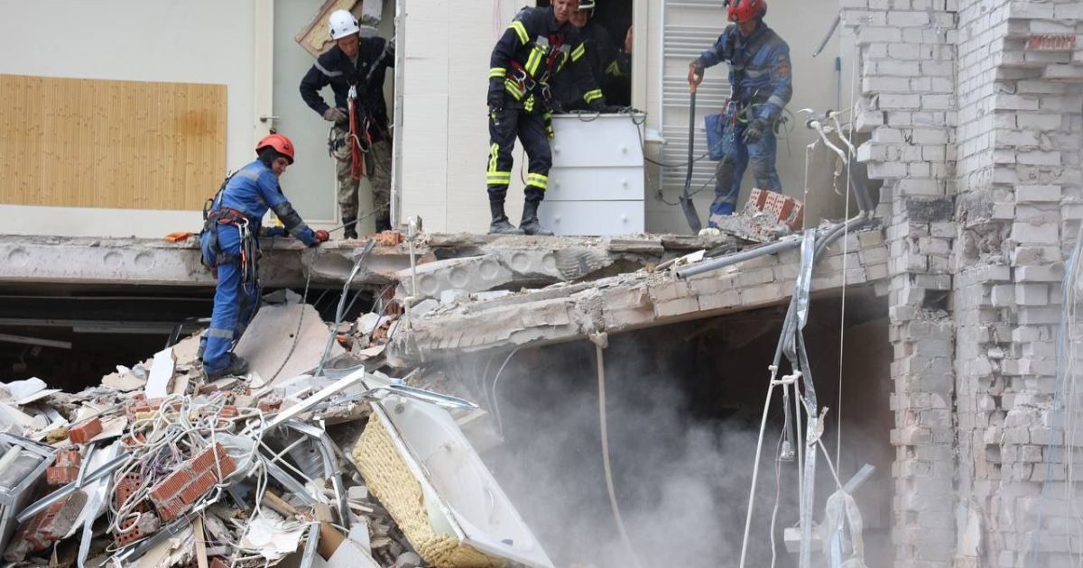 Рятувальник працюють на місці влучання російської ракети у багатоповерхівку у Дніпрі