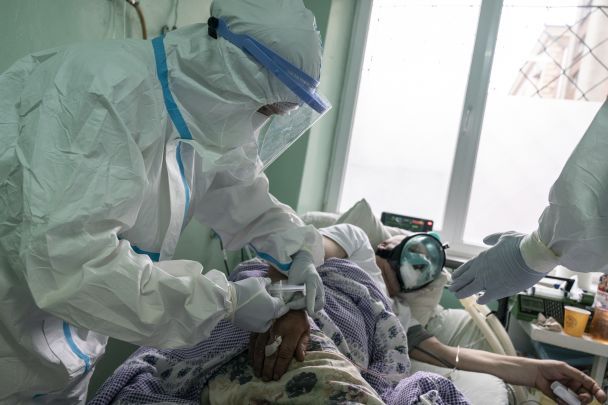На цьому фото, зробленому в понеділок, 4 травня 2020 року, лікарі в спеціальних захисних костюмах готують пацієнта з коронавірусом до рентгену легенів у відділенні інтенсивної терапії в Чернівецькій обласній лікарні / © Associated Press