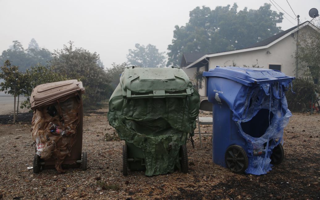Расплавленные мусорные контейнеры, поврежденные огнем в городе Миддлтон, штат Калифорния. Огонь от лесных пожаров быстро распространяется по штату и охватил уже 16 тысяч гектаров. / © Getty Images