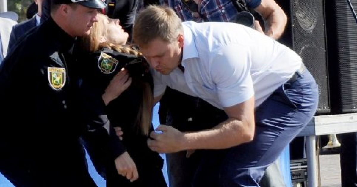 Премьер-министр Украины Арсений Яценюк подхватывает девушку-полицейскую, которая упала в обморок во время церемонии принятия присяги в Харькове. В этот день в Харькове приняли присягу около 800 новых патрульных полицейских. / © УНИАН