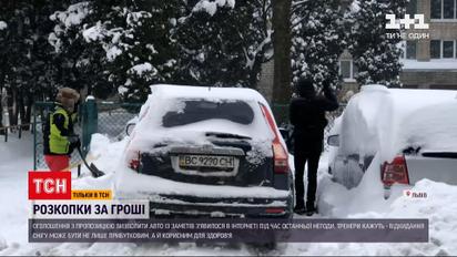 Новини України: у Львові заробляють гроші відкопуванням авто з-під снігу