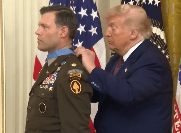 Президент Дональд Трамп надягає на шию військового Медаль Пошани  / © скриншот