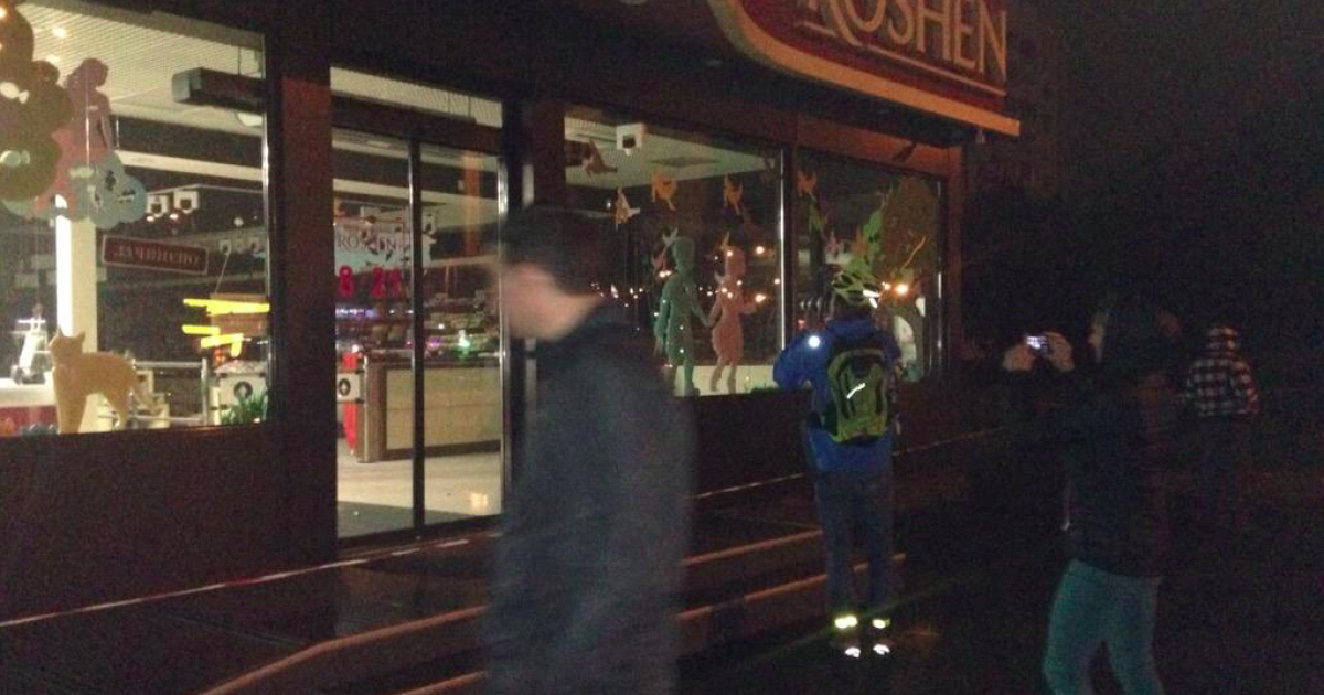 Прохожие фотографируют последствия взрыва в магазине Roshen на Оболони