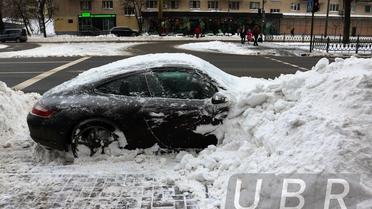 В Киеве коммунальщики забросали снегом припаркованный элитный Porsche