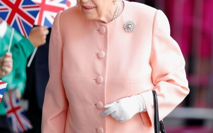 В персиковом пальто и шляпе с перьями: королева Елизавета II в ярком наряде прокатилась на поезде