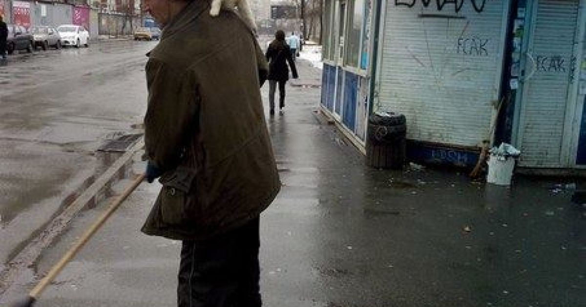 Мужчина подметает улицу и не обращает внимание на пушистых зверушек у себя на голове