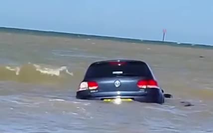 В Британии сняли горе-водителя, который пытается спасти унесенную в море машину
