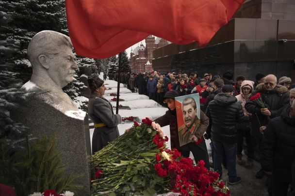 Прихильники Комуністичної партії з червоними прапорами і портретом Йосипа Сталіна шикуються для покладання квітів до його могили біля Кремлівської стіни, щоб відзначити 70-ті роковини його смерті на Красній площі в Москві, Росія, 5 березня 2023 року. / © Associated Press