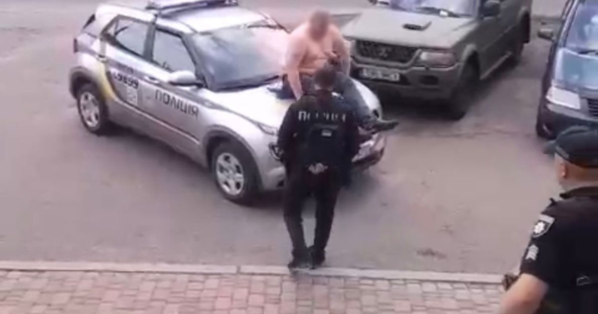 Мужчина вылез на капот полицейского автомобиля и повредил его/Фото: прокуратура Киева