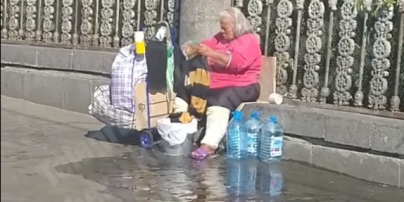 В Киеве на вокзале бездомная стирает вещи прямо на тротуаре и выливает воду под ноги прохожим: видео