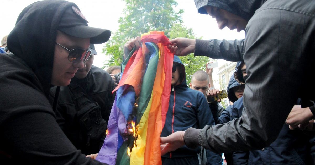 Мужчина поджигает флаг ЛГБТ возле здания Дворца бракосочетания в Харькове 17 мая