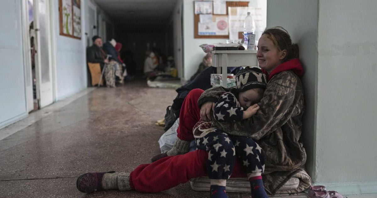 Anastasia Erashova cries as she hugs her child in a corridor of a hospital in Mariupol
