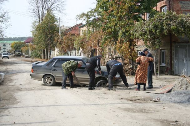Освобожденные местные жители вытаскивают провалившуюся в яму девятку на одной из центральных улиц Цхинвали / © Facebook.com/Аркадий Бабченко