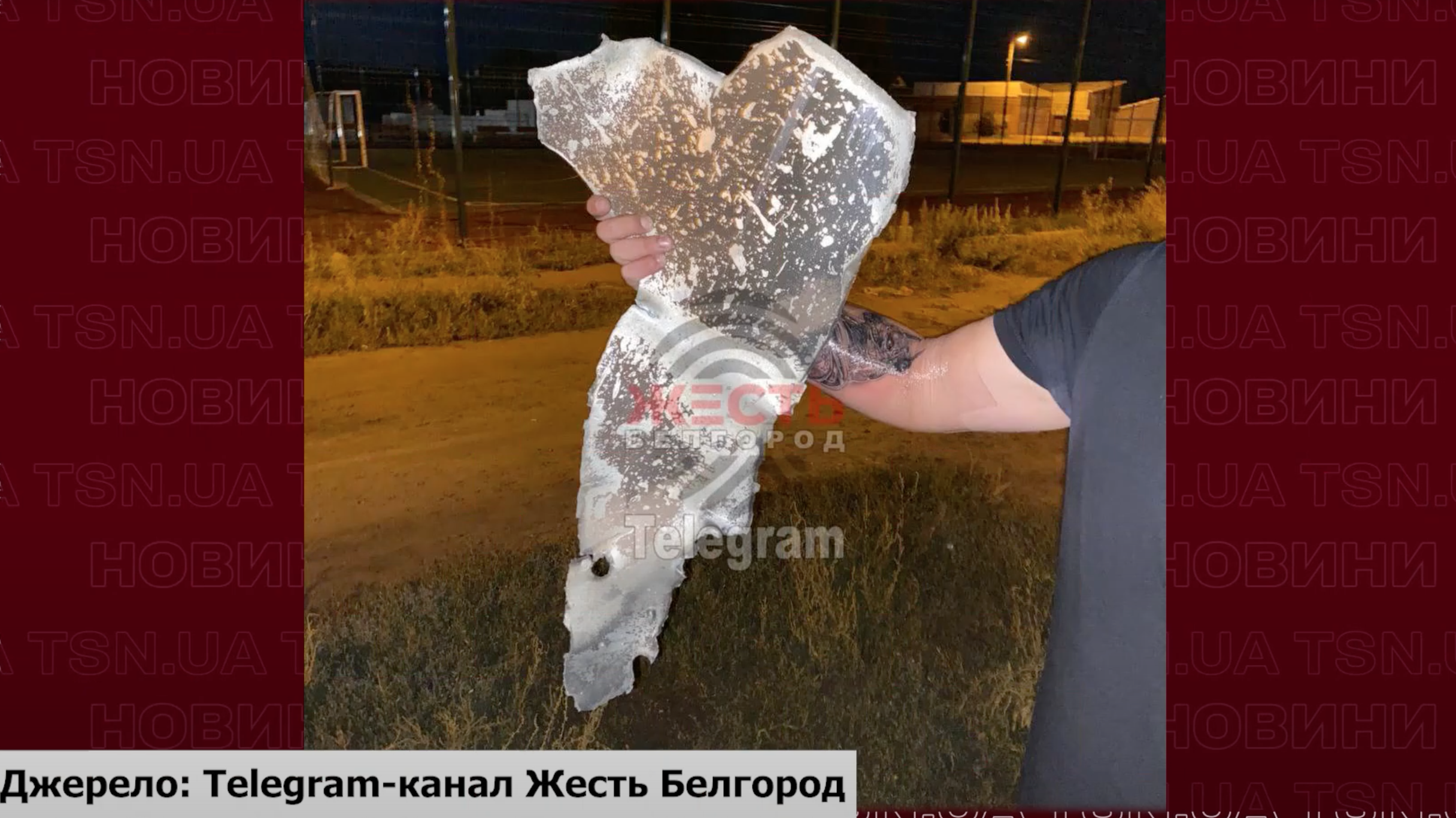 Житель Бєлгородської області тримає в руках уламки дрона / © 